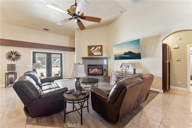 living room featuring ceiling fan, vaulted ceiling, french doors, and light tile patterned flooring