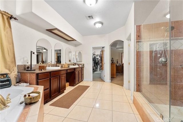 bathroom featuring a shower with shower door, vanity, ceiling fan, and tile patterned flooring