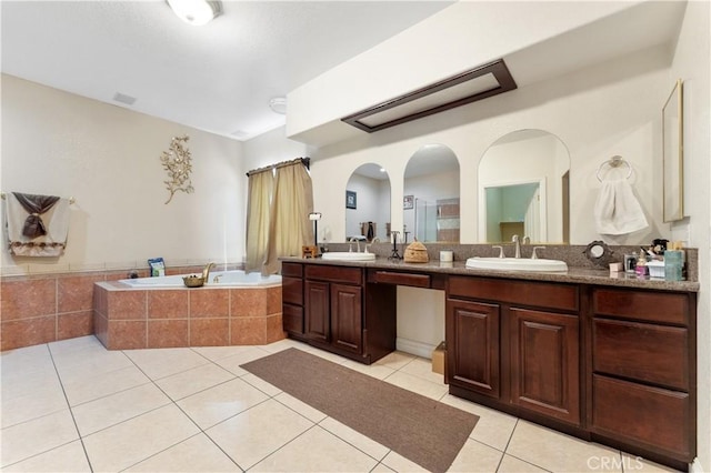 bathroom featuring tiled bath, tile patterned floors, and vanity