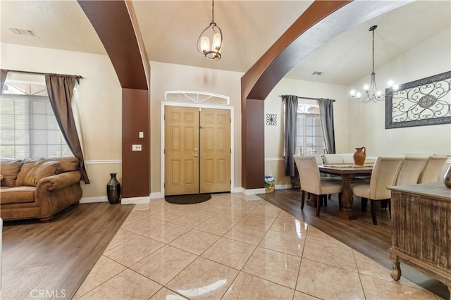 foyer with light tile patterned floors and a notable chandelier