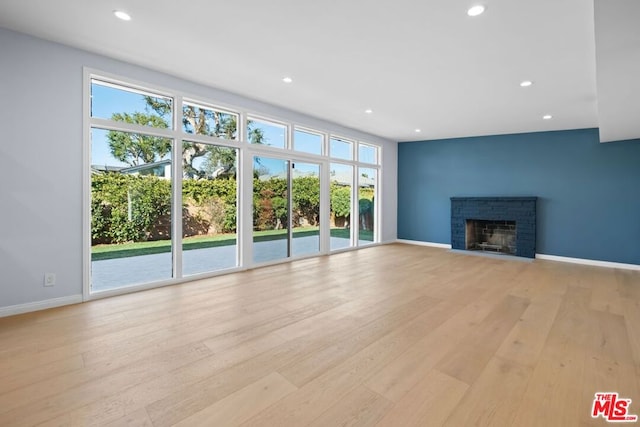 unfurnished living room featuring a fireplace and light hardwood / wood-style floors