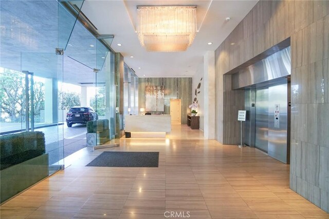 corridor with floor to ceiling windows and light tile patterned floors