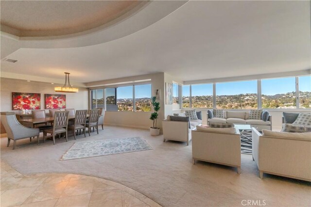 carpeted living room featuring a raised ceiling