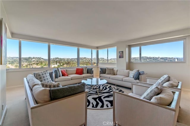 living area featuring light carpet and baseboards