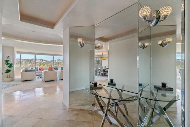 dining space with a raised ceiling and tile patterned floors