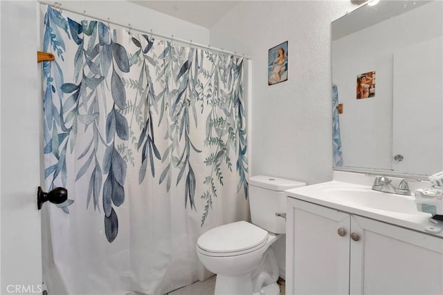 bathroom with walk in shower, vanity, and toilet