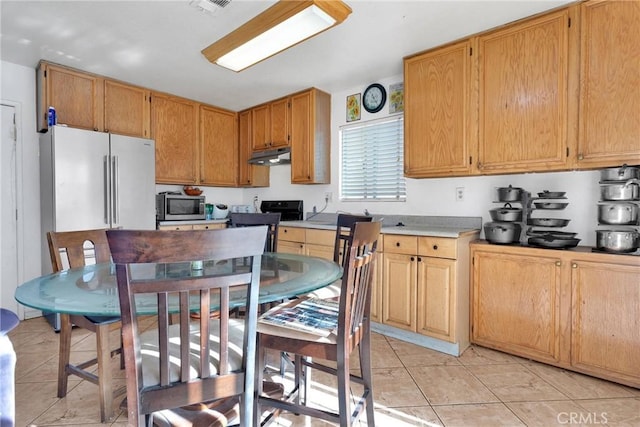 kitchen featuring black range oven and light tile patterned floors