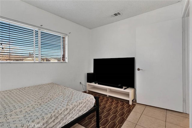 tiled bedroom with a textured ceiling