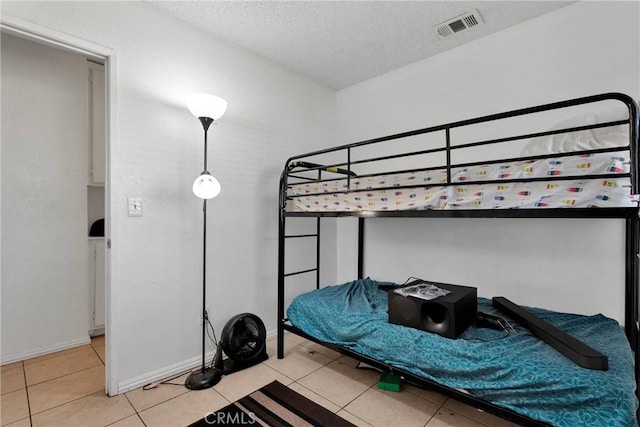 bedroom featuring a textured ceiling and light tile patterned flooring