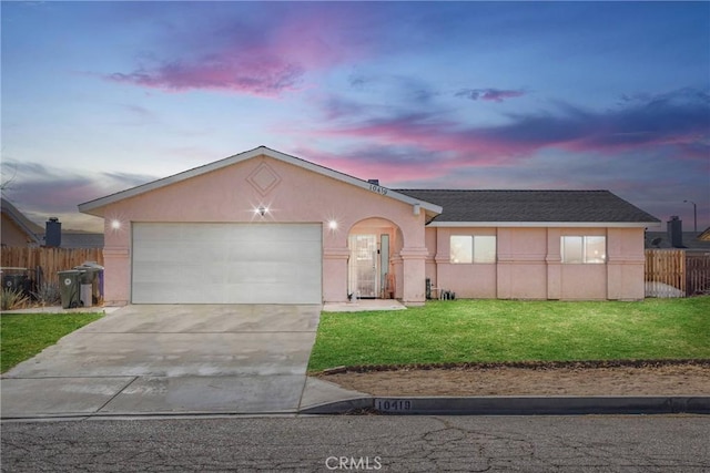 ranch-style house featuring a lawn and a garage