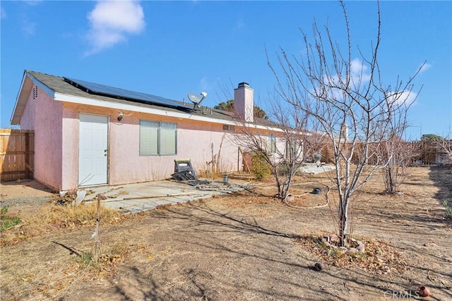 back of house with a patio and solar panels