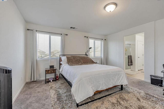 bedroom featuring light colored carpet and connected bathroom