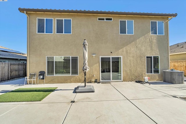 rear view of house with central AC unit and a patio