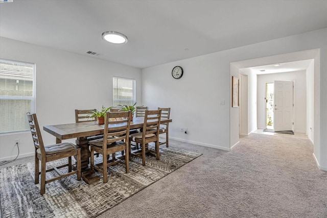 carpeted dining space with a wealth of natural light