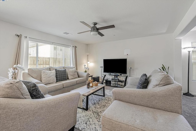 carpeted living room with ceiling fan