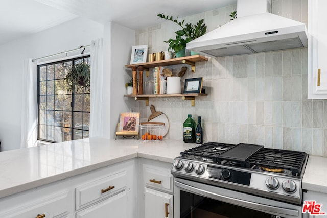 kitchen featuring range hood, white cabinetry, decorative backsplash, and stainless steel gas range oven