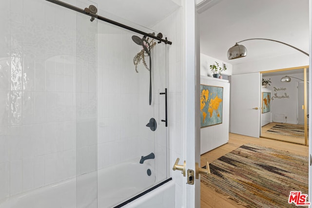 bathroom featuring enclosed tub / shower combo and hardwood / wood-style flooring