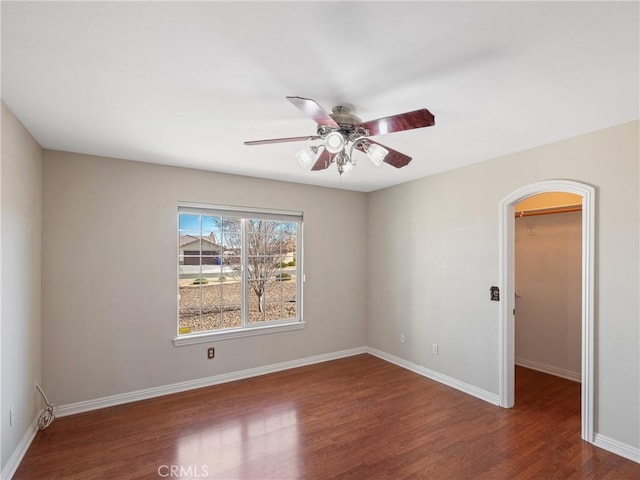 unfurnished room featuring dark wood-type flooring and ceiling fan