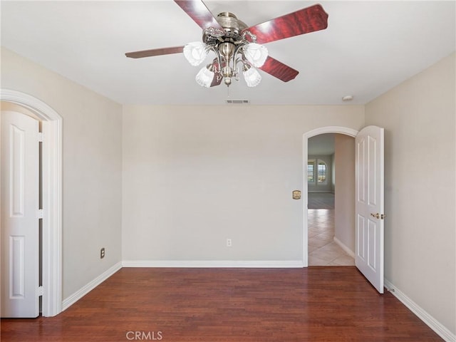 spare room featuring ceiling fan and dark hardwood / wood-style floors