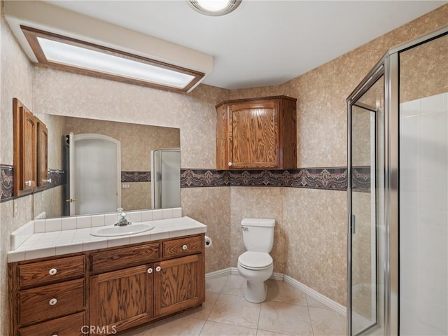 bathroom with toilet, vanity, and walk in shower