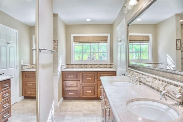 bathroom featuring tasteful backsplash, vanity, tile patterned flooring, and plenty of natural light