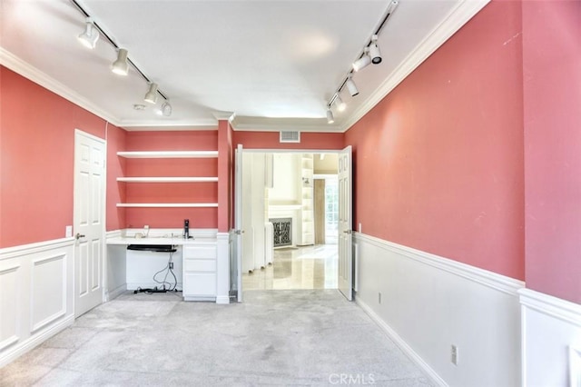 kitchen featuring white cabinets, ornamental molding, light carpet, and a fireplace