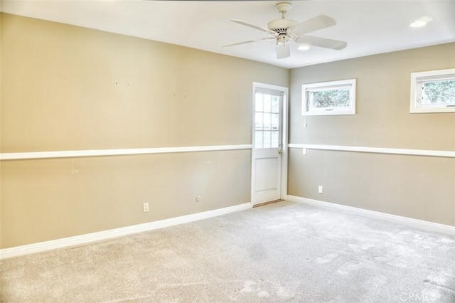 spare room featuring ceiling fan and light colored carpet