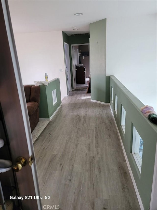 corridor with hardwood / wood-style flooring