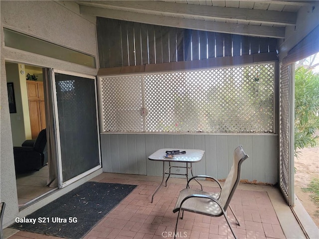 sunroom featuring beamed ceiling