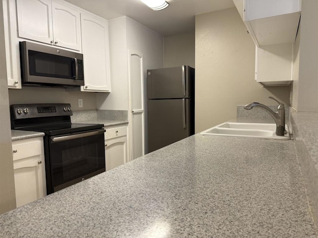 kitchen with sink, stainless steel appliances, and white cabinetry