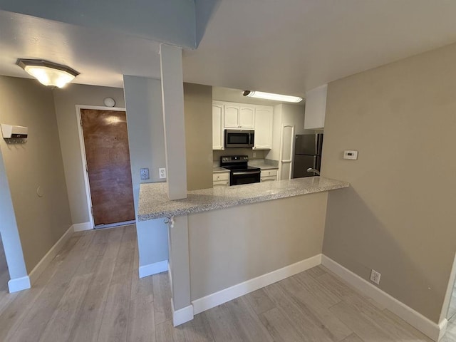 kitchen featuring kitchen peninsula, stainless steel appliances, light hardwood / wood-style flooring, and white cabinets