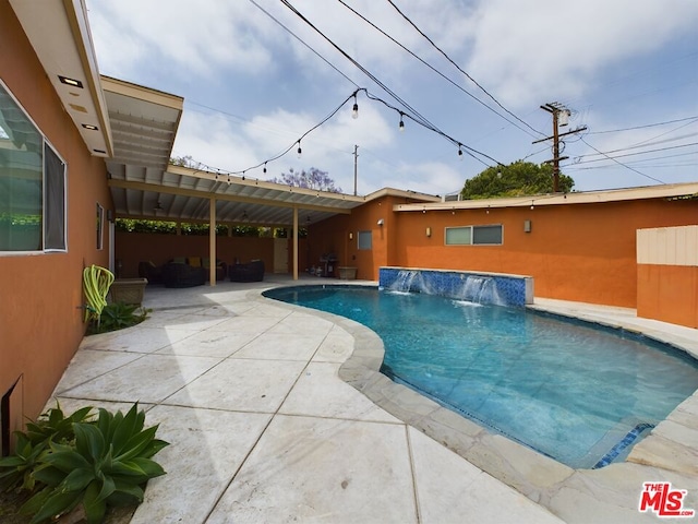 view of pool with pool water feature, a patio area, and an outdoor living space