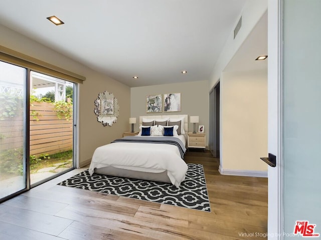 bedroom featuring wood-type flooring and access to outside