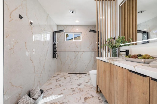 bathroom featuring tile walls, toilet, vanity, and tiled shower