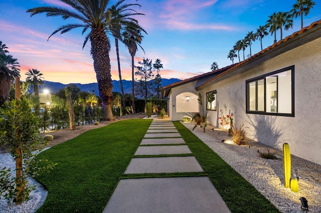 yard at dusk featuring a mountain view