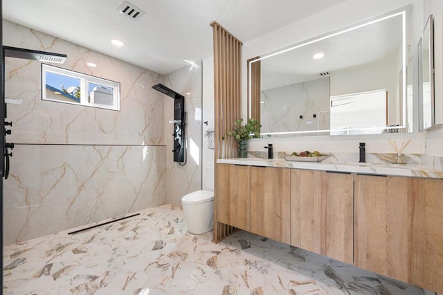 bathroom with toilet, vanity, and a tile shower