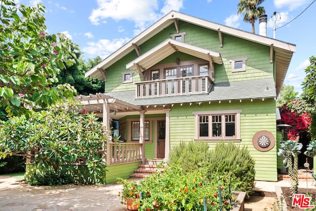 view of front of property featuring a balcony and a pergola