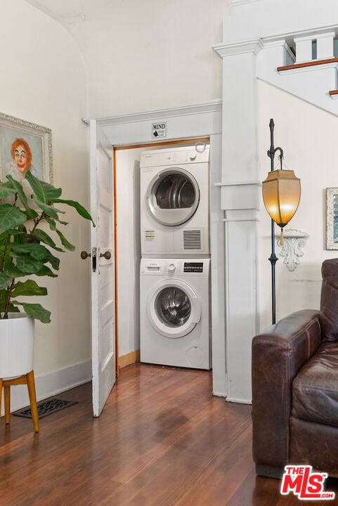 washroom featuring dark wood-type flooring and stacked washer and clothes dryer