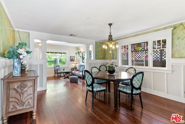 dining area featuring dark hardwood / wood-style flooring, an inviting chandelier, and ornamental molding