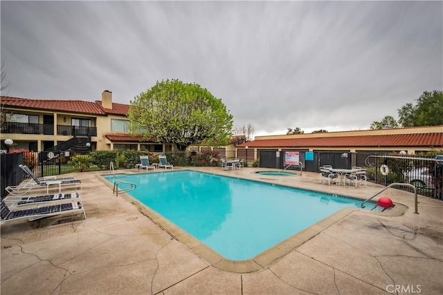 view of pool with a patio area and a hot tub