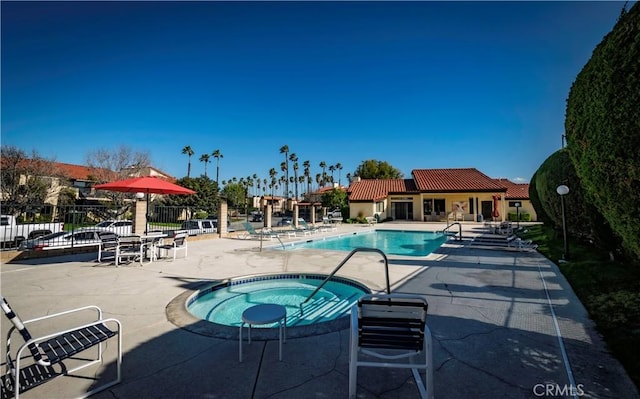 view of swimming pool featuring a hot tub and a patio