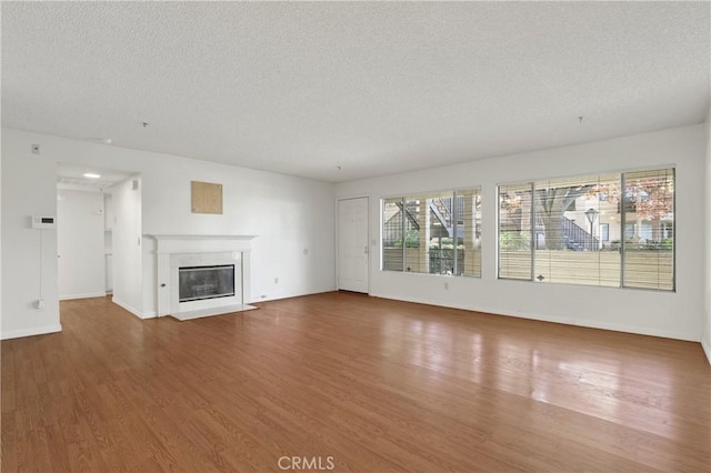 unfurnished living room featuring a textured ceiling and hardwood / wood-style flooring