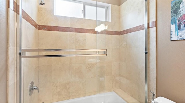 bathroom featuring bath / shower combo with glass door and toilet