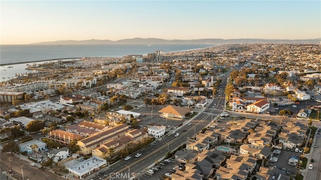 aerial view at dusk featuring a water view