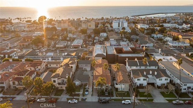 aerial view at dusk featuring a water view