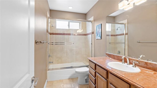 full bathroom featuring toilet, combined bath / shower with glass door, tile patterned floors, and vanity