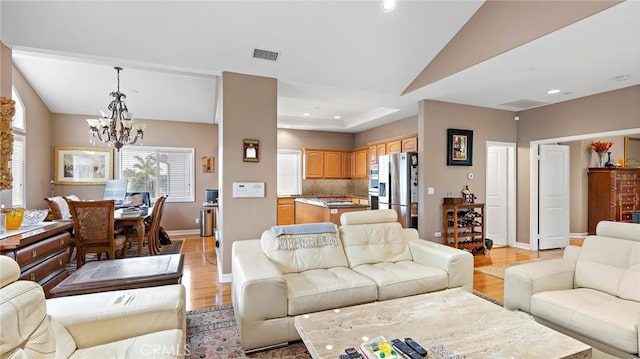 living room with light wood-type flooring and a notable chandelier