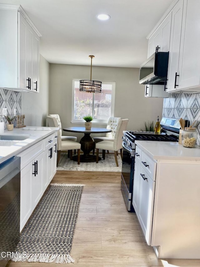 kitchen featuring dishwasher, gas stove, white cabinetry, and range hood