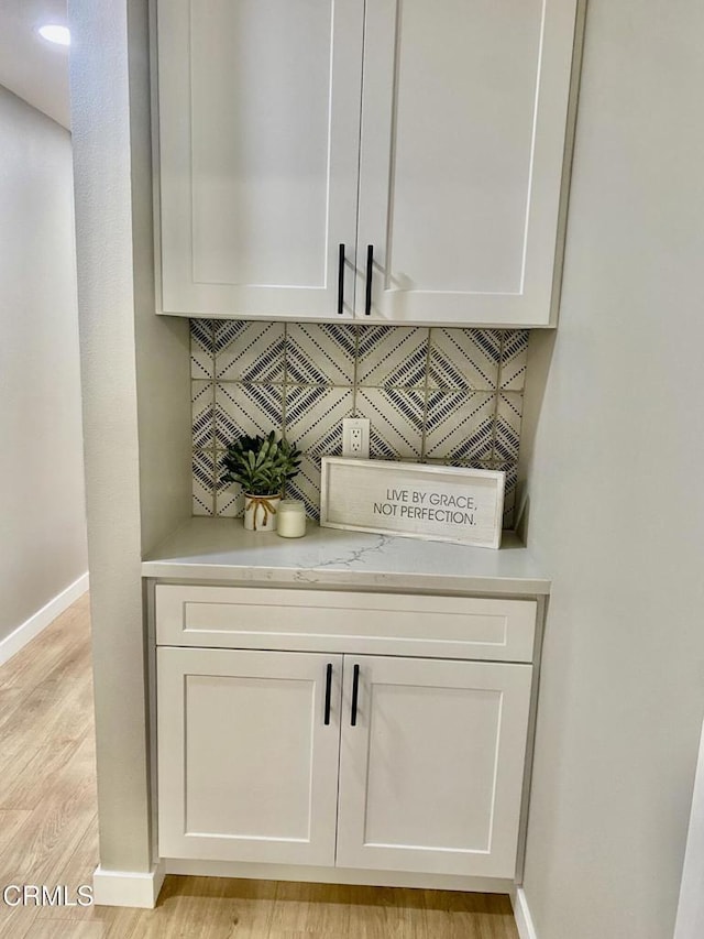 interior details featuring hardwood / wood-style floors and backsplash