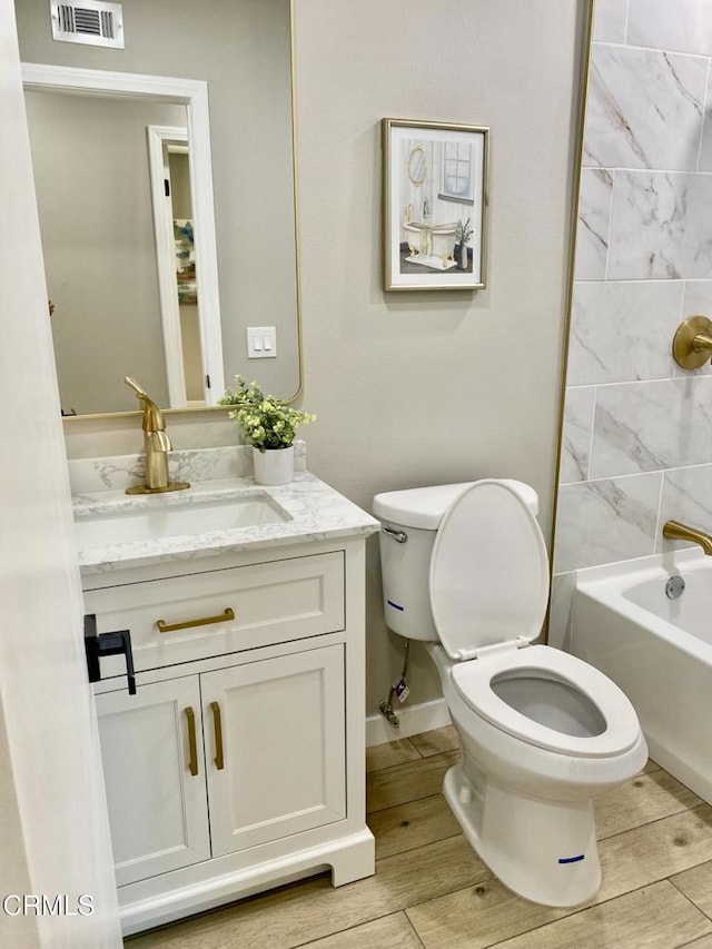 full bathroom featuring vanity, toilet, and tiled shower / bath